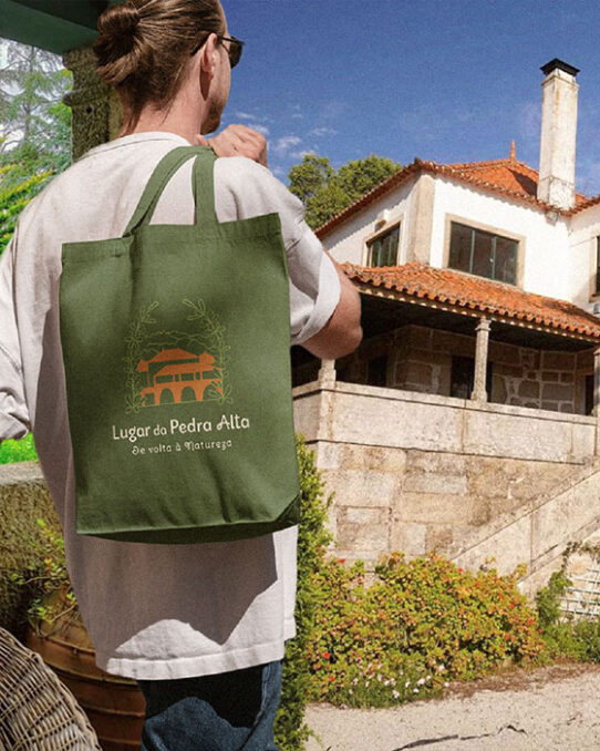 A boy wearing a Lugar da Pedra Alta organic shopping bag