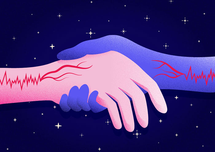 Two hands holding each other under the stars. The blood veins are visible on the hands.