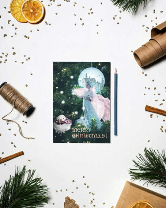 Christmas card mockup depicting The frozen kingdom presented on a Christmas card, placed on a flat surface between dried orange slices, Christmas tree branches, vanilla sticks, wrapping paper and twine for presents